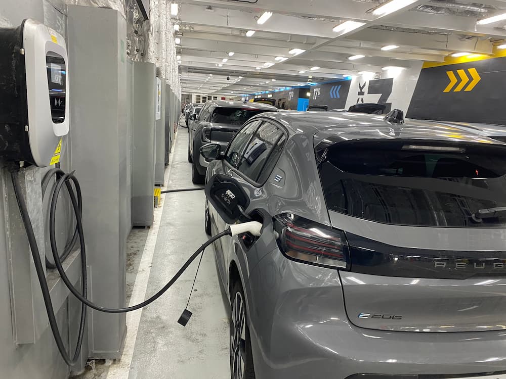 Peugeot e-208 plugged into an onboard charger on the car deck of a P&O ferry between Dover and Calais